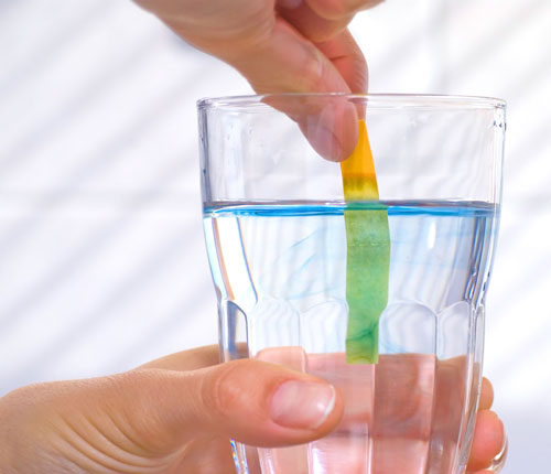 pH litmus test in glass of water